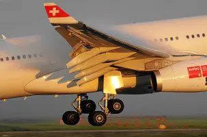 Swiss Airbus A330 landet einige Minuten nach Sonnenaufgang in Zürich Kloten. Die kondensierende feucht Luft bildet einen feinen Nebel über dem Flügel.